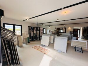 Showroom moderne : dalles de carrelage en grès cérame et faïence sur présentoirs. Chauffage au sol. Logos Keratile, Margres. Banderole Labic D.