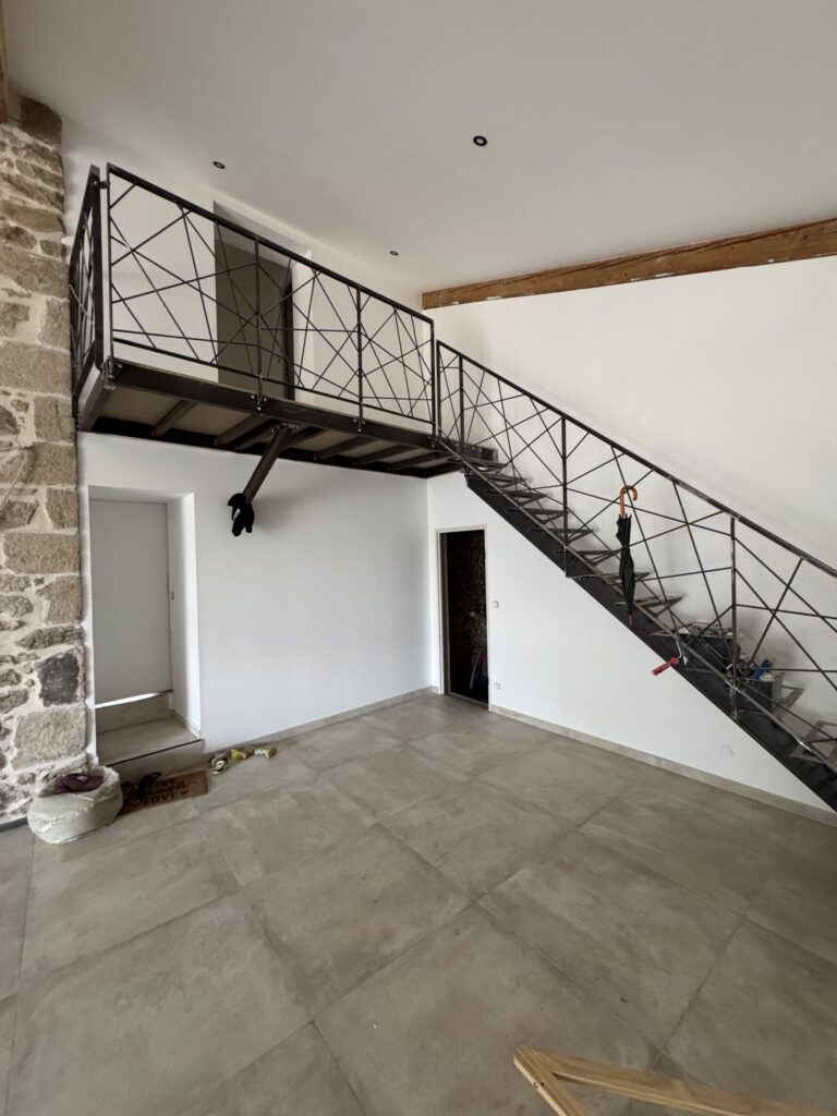 Escalier Industriel et Mezzanine pour Intérieur Moderne Escalier industriel en métal noir avec garde-corps géométrique et mezzanine dans un intérieur moderne aux murs blancs.